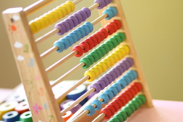 Colorful beads on wooden dowels.
