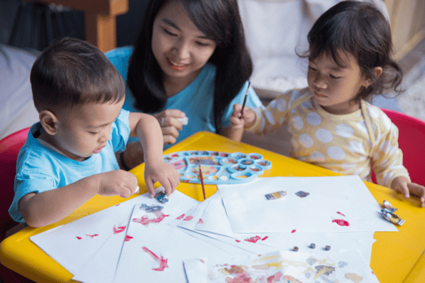 Two children painting with water colors.