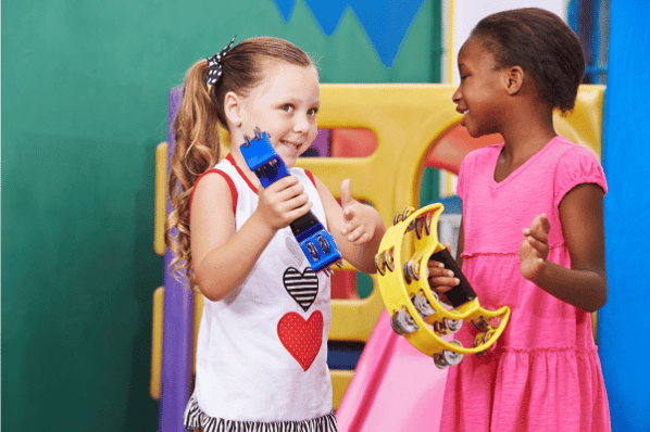 Two girls playing music with tambourines