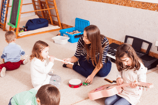Teacher and children learning music at daycare.