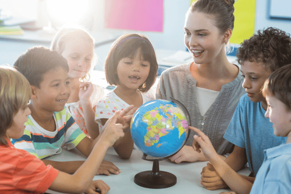 Female teacher showing a globe to preschool children