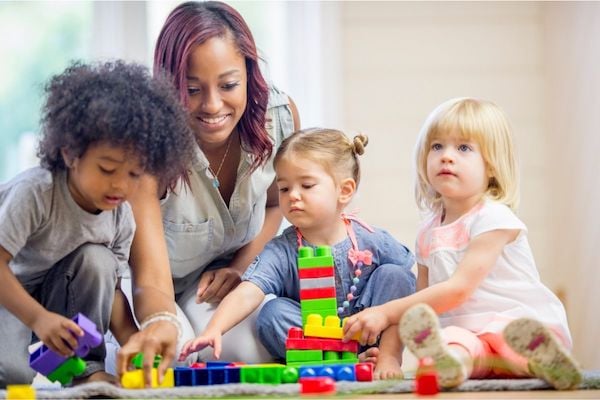 Children and their teacher playing with blocks.