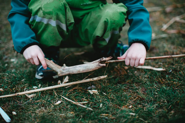 young child gathering sticks 