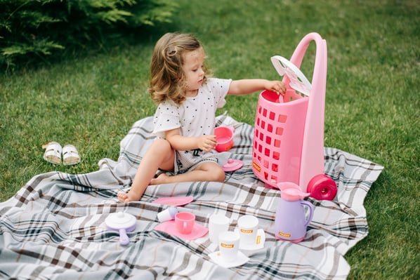 Child pretend playing on picnic blanket