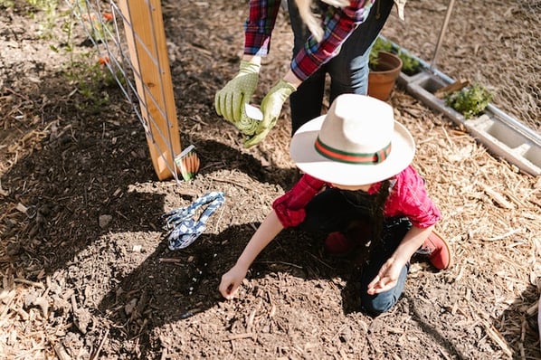 child gardening with teacher