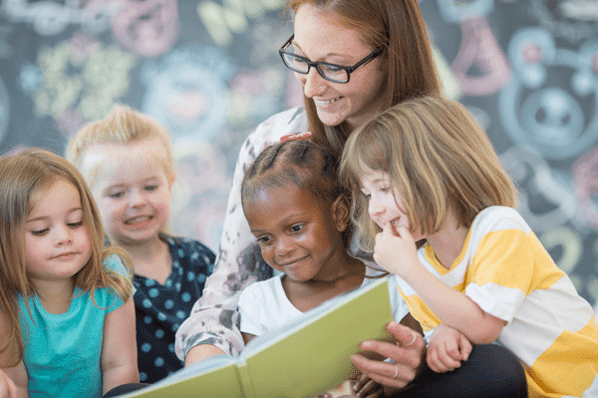 Teacher reading to children at preschool