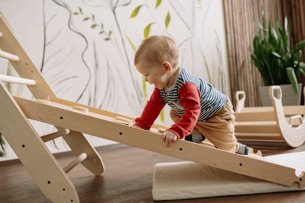 Toddler climbing up wooden ladder