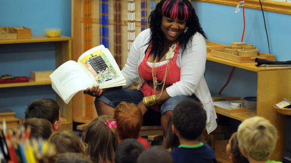 A teacher reading a book to a preschool class.