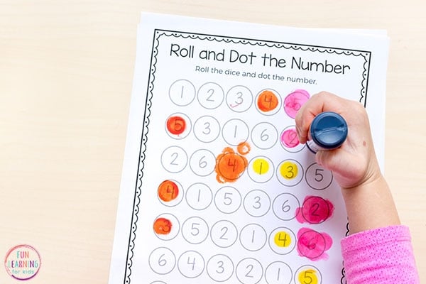 a child coloring numbers in a paper sheet with numbers 1-10